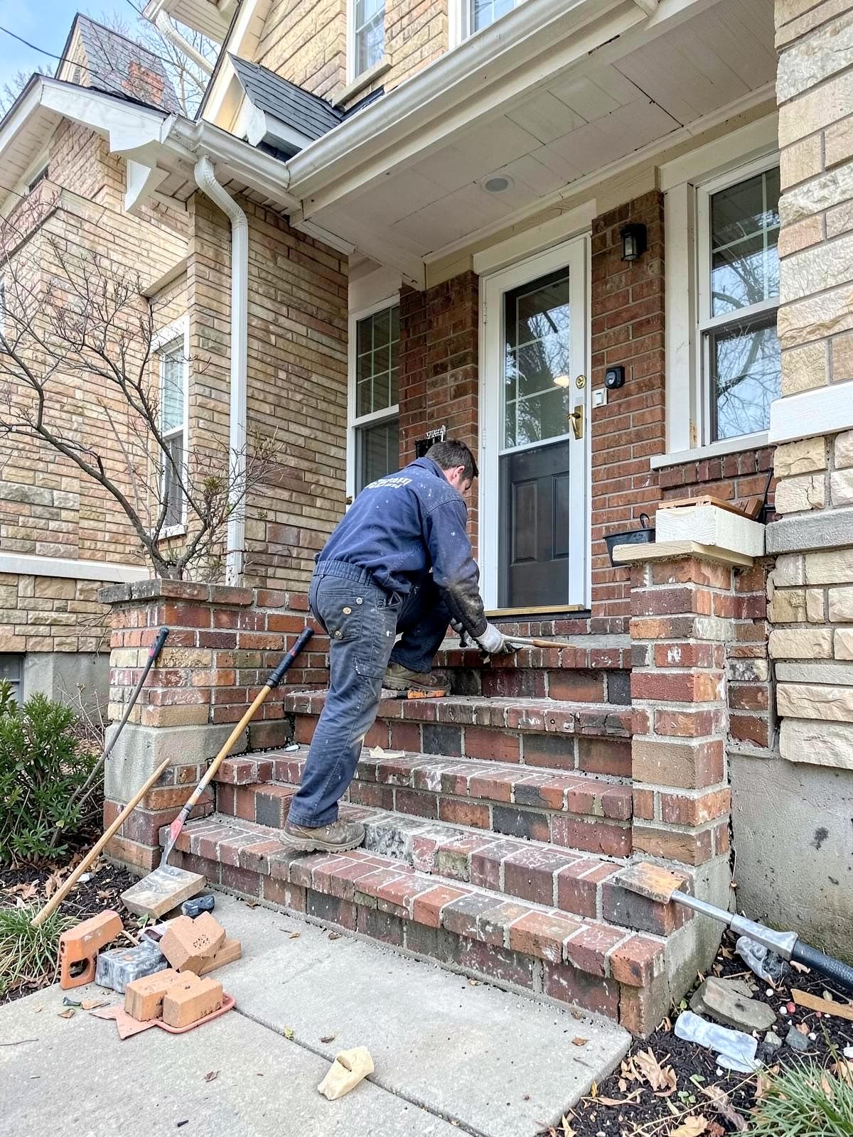 Mason rebuilding brick front steps on a GTA home